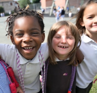 Дівчатка у шкільній формі вчаться доглядати за зубами, використовуючи щітки з картону